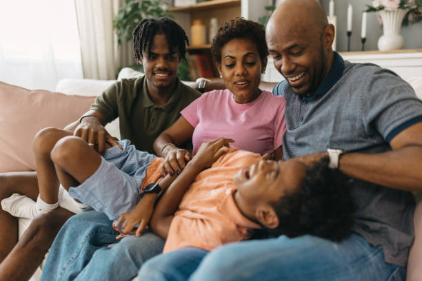 istock Family laughing together while playing on cozy living room sofa 2163417421