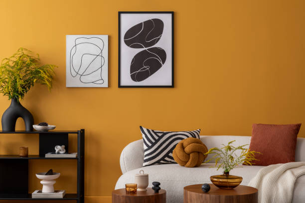 istock Interior design of cozy living room with mock up poster frame, boucle sofa, patterned pillows, black rack, wooden coffee table, vase with flowers and personal accessories. Home decor. Template. 2163417695