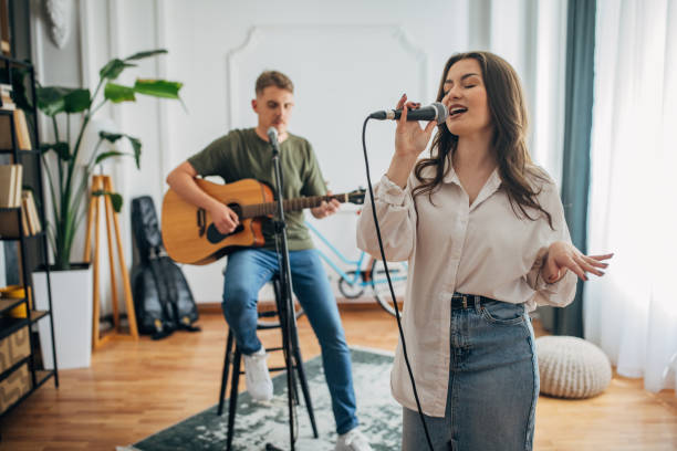 istock Duo performing with guitar and microphone indoors, smiling 2163417702