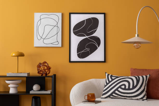istock Cozy composition of warm living room interior with mock up poster frame, boucle sofa, patterned pillows, lamp, black rack, yellow wall, books and personal accessories. Home decor. Template. 2163417709