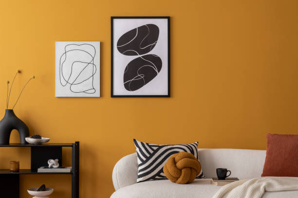 istock Interior design of cozy living room with mock up poster frame, boucle sofa, patterned pillows, black rack, wooden coffee table, vase with flowers and personal accessories. Home decor. Template. 2163417905