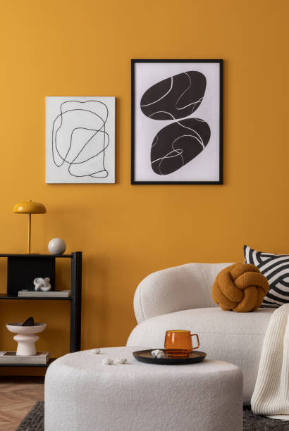 Warm and cozy living room interior with  mock up poster frame, boucle sofa, patterned pillows, white plaid, black rack, marble lamp, yellow wall, books and personal accessories. Home decor. Template.