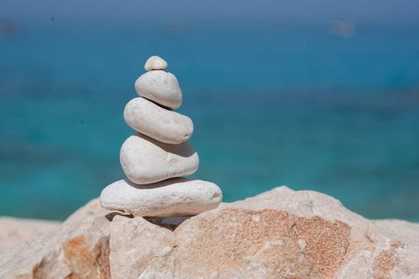 A peaceful image by the sea, with white stones on a rock under a clear sky, creating tranquility and harmony