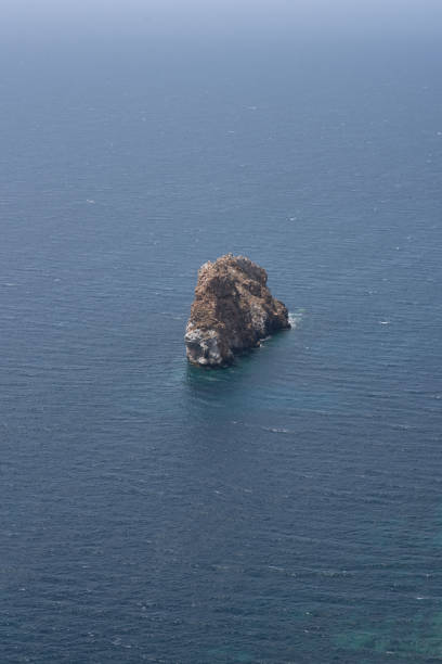Imagine a small island nestled in the middle of the vast ocean, surrounded by azure waters. The calm and serene landscape offers a breathtaking view of the horizon