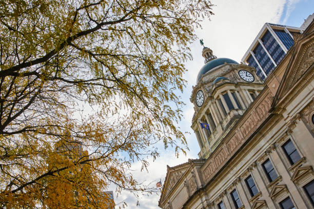Autumn leaves frame a historic Beaux-Arts style courthouse in downtown Fort Wayne, Indiana, illustrating the timeless grandeur of government architecture.