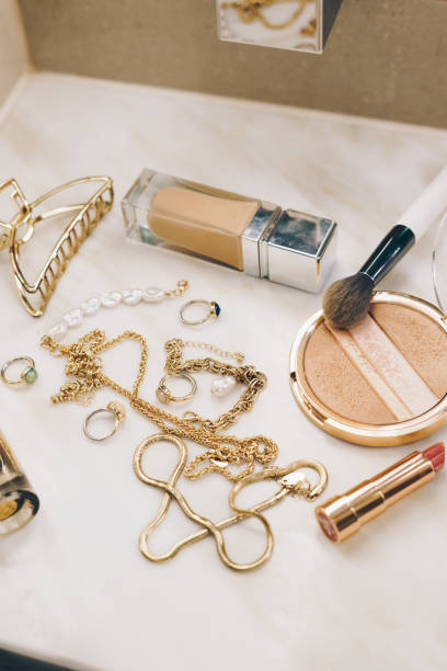 istock Gold jewellery and make up products  on a marble surface 2163432567