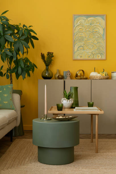 istock Creative composition of living room interior with mock up poster frame, green coffee table, beige sideboard, dried flowers, plants in flowerpots and personal accessories. Home decor. Template. 2163440249
