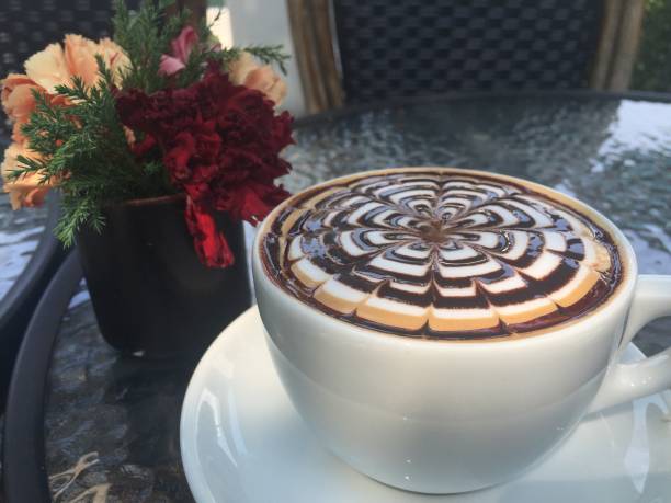 istock Artful Coffee Cup with Floral Bouquet on Cafe Table 2163443366