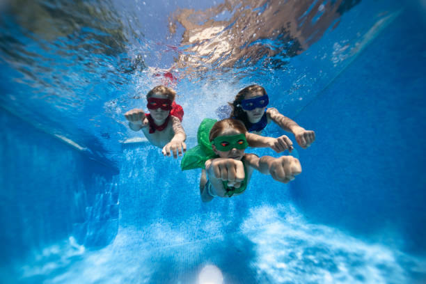 istock Three kids playing superheroes and playing underwater. 2163444472