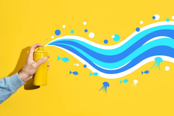 Graffiti painter with balloon paint in his hands draws ocean wave and small fish pattern