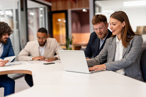 istock Happy business colleagues talking while using laptop in the office 2163444830
