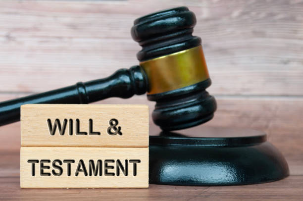 istock Will and testament text engraved on wooden blocks with lawyer gavel background 2163444832