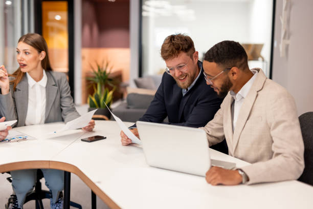 istock Happy business colleagues talking while using laptop in the office 2163446240
