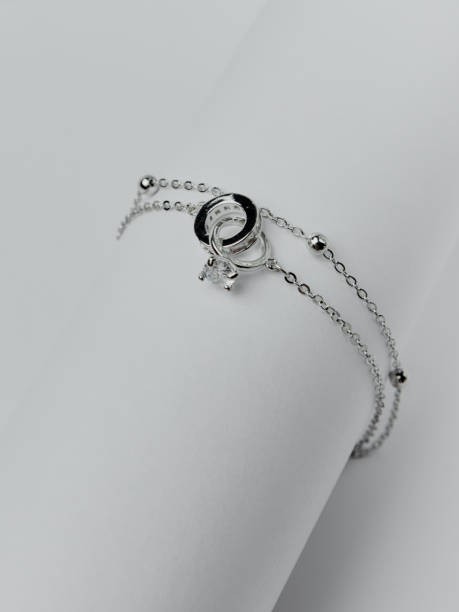 istock A silver bracelet with a round stone on a white background. An elegant decoration with a minimalistic design, suitable for any occasion. 2163450514