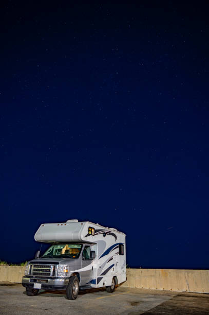 Motor home in parking lot of Salisbury, Massachusetts, with sky and stars during summer blue hour, close to the beach