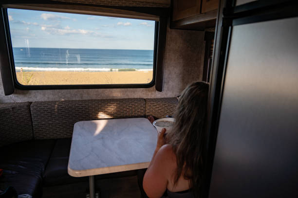 istock Woman having breakfast facing motorhome window 2163453364