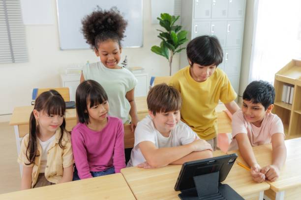 istock A group of diverse elementary school students are gathered around a tablet, engaged in an interactive learning activity. 2163461125