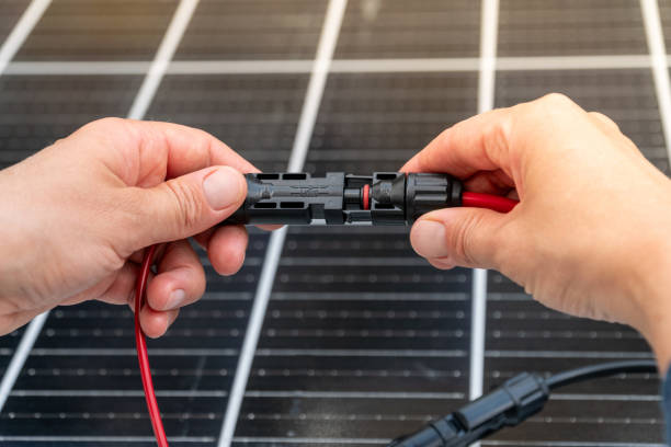 istock Close up of technician's hands connecting mc4 connectors over the solar panel. 2163473342
