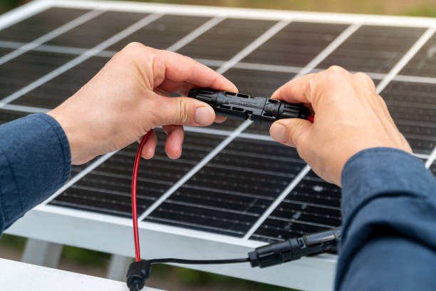 istock Close up of technician's hands connecting mc4 connectors over the solar panel. 2163473658