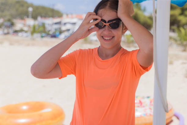 Happy girl smiling when putting on her swimming glasses