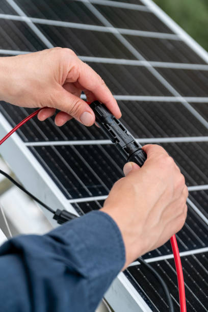 istock Close up of technician's hands connecting mc4 connectors over the solar panel. 2163473799