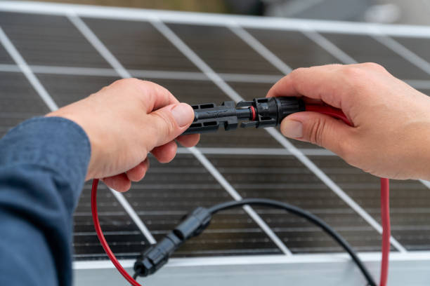 istock Close up of technician's hands connecting mc4 connectors over the solar panel. 2163473937