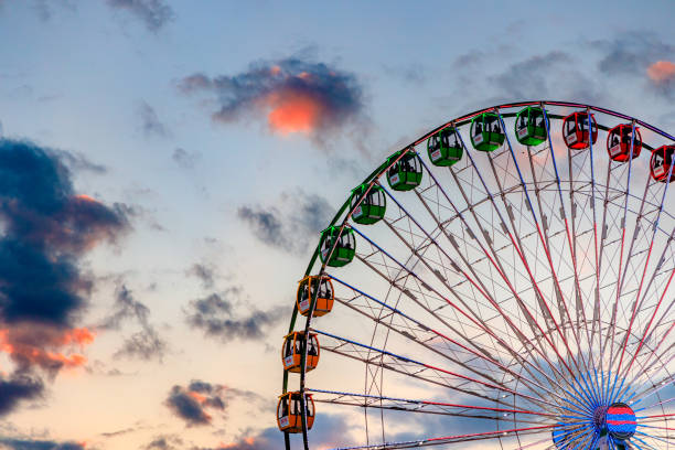 Colorful Ferris wheel cabins set against a bright blue sky, embodying the excitement of a sunny amusement park day