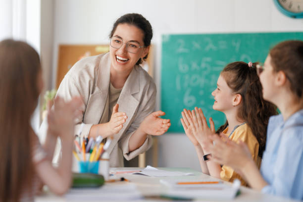 istock Happy kids and teacher at school 2163479877
