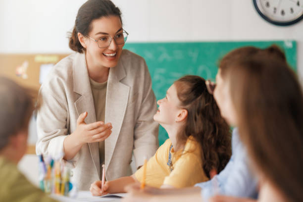 istock Happy kids and teacher at school 2163479928