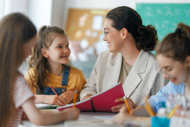 istock Happy kids and teacher at school 2163480005
