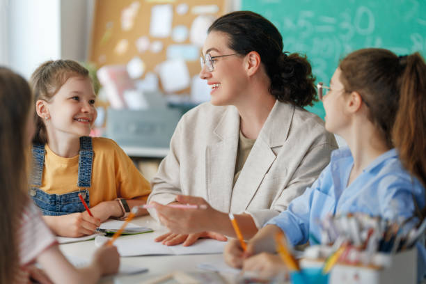 istock Happy kids and teacher at school 2163480009