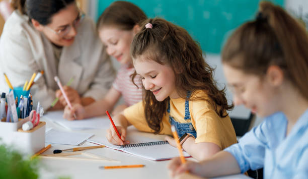istock Happy kids and teacher at school 2163480023