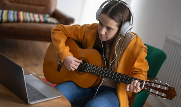 istock Focused Beginner Guitarist Practices at Home 2163480035