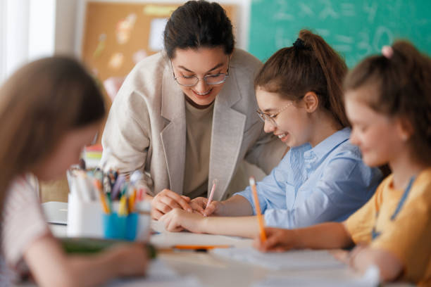 istock Happy kids and teacher at school 2163480099