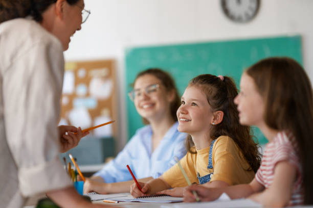 istock Happy kids and teacher at school 2163480102