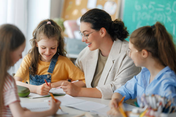 istock Happy kids and teacher at school 2163480171