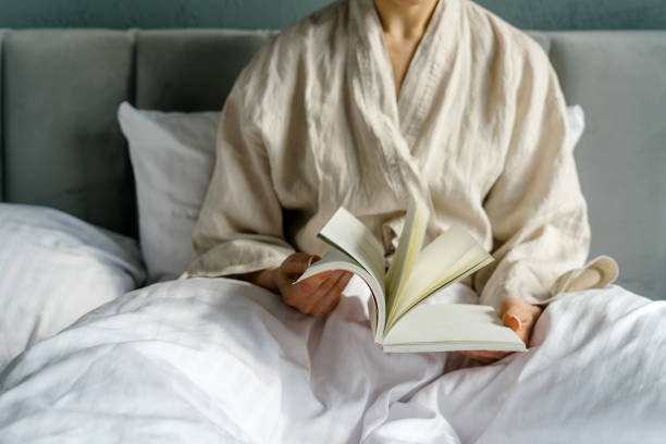 istock Woman reading book on bed spending morning at home 2163485126