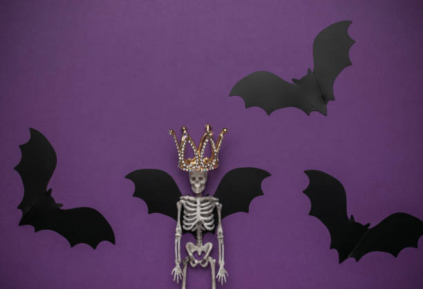 istock Halloween Skeleton with Crown Surrounded by Bats on Purple Background 2163488086