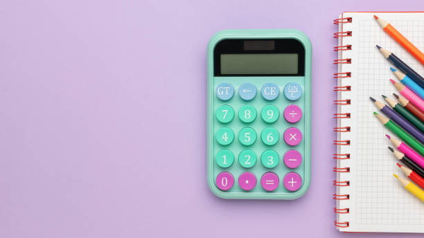 istock Colorful Calculator and Notepad with Pencils on Purple Background 2163488105