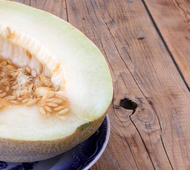 istock Image of a ripe cut melon with seeds on a plate. 2163488950