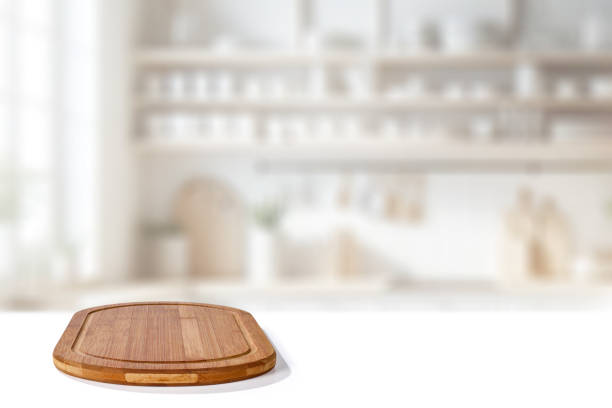istock Wooden cutting board with blurred bright kitchen interior. Natural window daily sunlight. Copy space for products. 2163489049