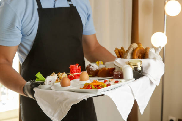 istock Room service hotel staff carries breakfast tray 2163491458