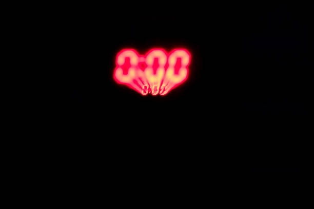 Red digital clock numbers on a black background, three zeros in a blurred zoom