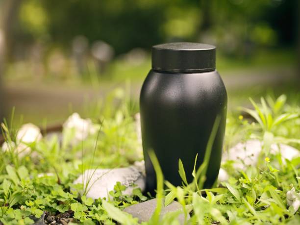 Black urn prepared for funeral at a green field