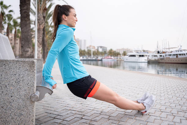istock A young woman is doing exercise on a park bench 2163494017