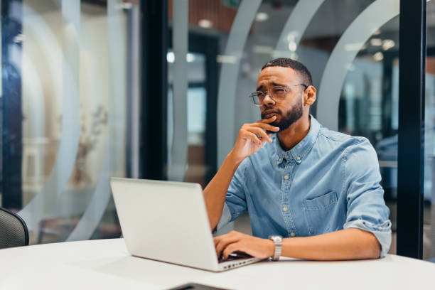 istock Businessman working on his laptop and thinking 2163494617