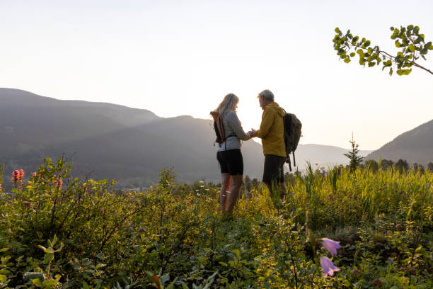 istock Mature hiking couple share phone in meadow 2163494800