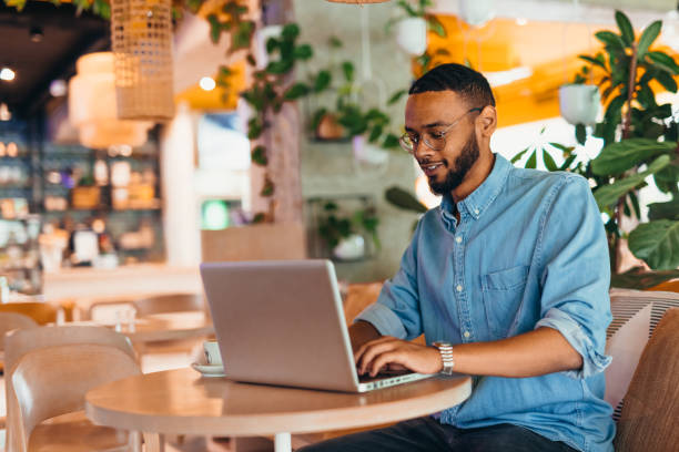 istock Young man sitting in coffee shop and using laptop 2163495160
