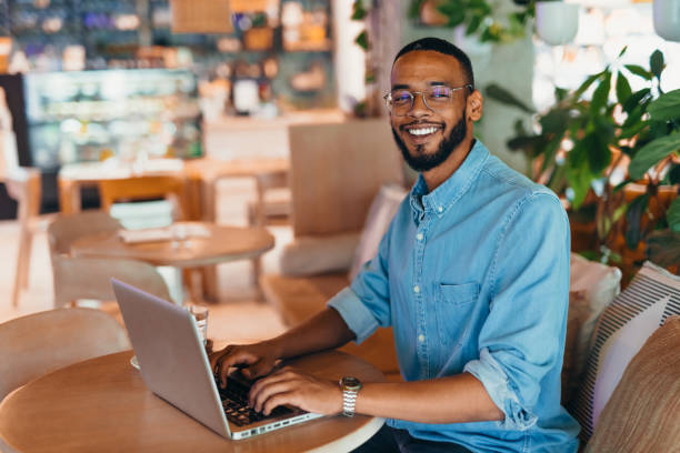 istock Young man sitting in coffee shop and using laptop 2163495192