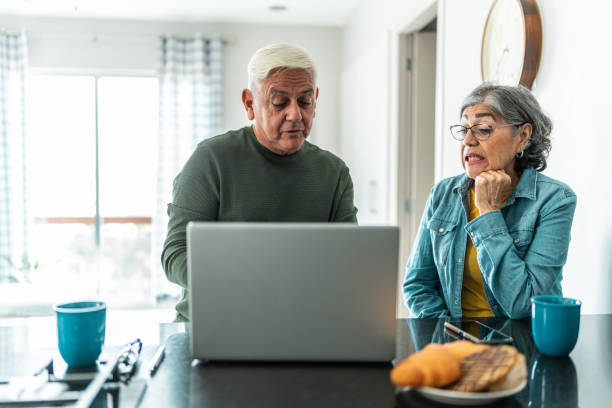 istock Senior couple using laptop at home 2163495268